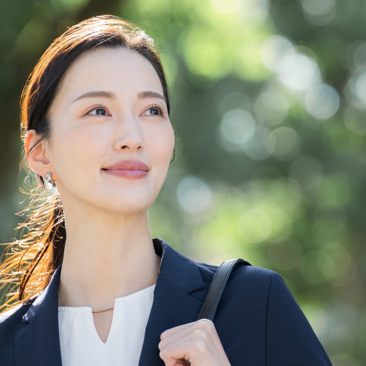 Seorang wanita muda mengenakan jas profesional sedang menatap ke depan dengan ekspresi percaya diri dan tenang, menggambarkan proses memahami diri melalui Tes Mind Modes™ Pribadi.